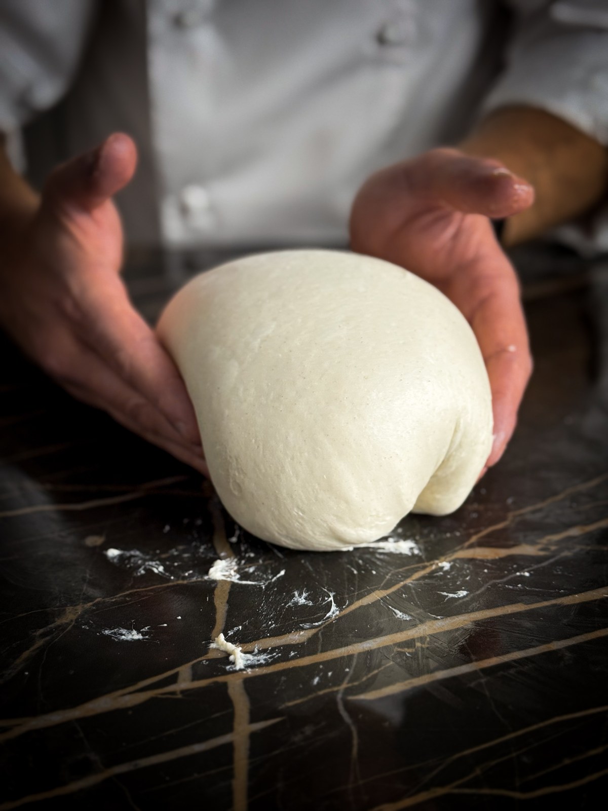 Hands shaping fresh pasta dough during a private cooking class on Lake Como